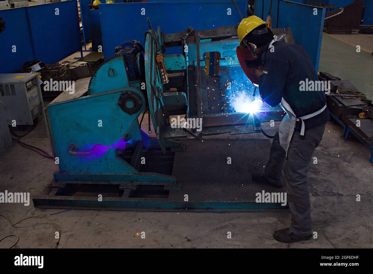 Un soldador está utilizando una máquina de soldadura por arco eléctrico en  un taller de fabricación Fotografía de stock - Alamy