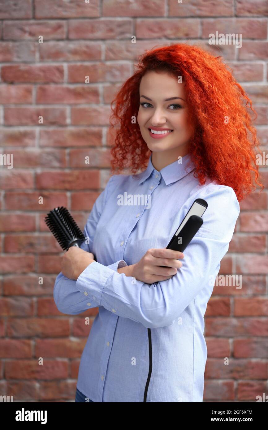 Hermosa niña de cabello rojo con peine y plancha para el pelo Fotografía de  stock - Alamy
