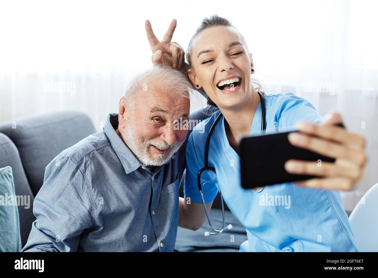 enfermero médico de atención a ancianos selfie cuidador ayudar a la jubilación casa teléfono móvil smartphone celular Foto de stock