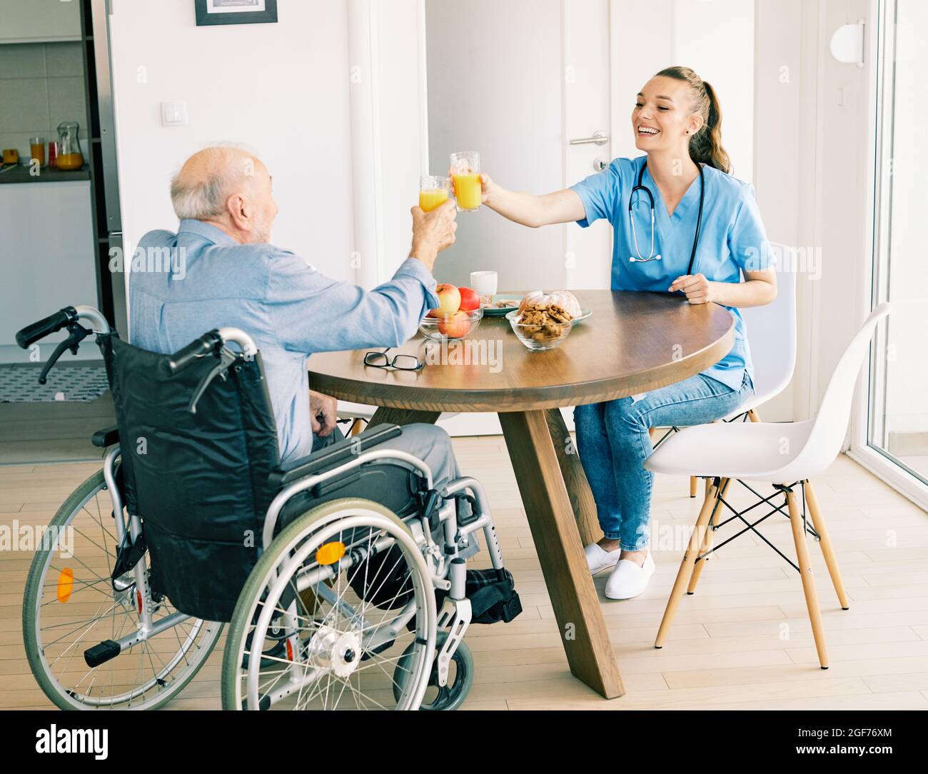 enfermero médico cuidador de cuidados mayores ayuda asistencia silla de ruedas retiro hogar ancianos hombre Foto de stock