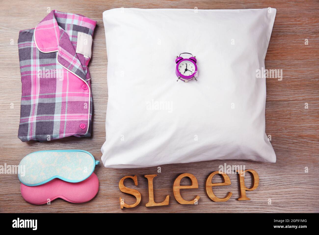 Sueño de la palabra con pijamas, máscaras y un pequeño reloj en una almohada  blanca Fotografía de stock - Alamy