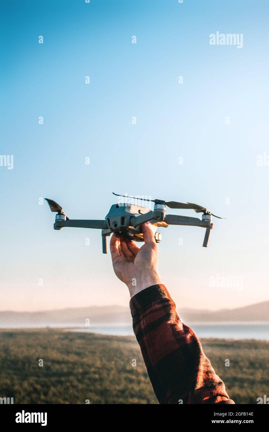 Disparo vertical de una persona lanzando un drone moderno en un campo bajo  la luz del sol Fotografía de stock - Alamy