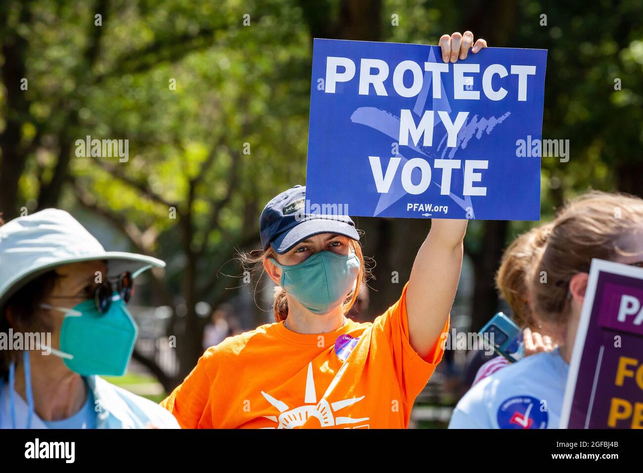 Washington, DC, EE.UU., 24 de agosto de 2021. En la foto: Una manifestante tiene una señal que pide a la Presidenta Biden y al Congreso que protejan su voto durante una manifestación de derechos de voto en la Casa Blanca. La Liga de Mujeres Votantes, Gente por la Vía Americana, Los Votantes Negros importan, y muchas otras organizaciones auspiciaron la manifestación para presionar al Congreso y al Presidente Biden para que protejan los derechos de voto después de que muchos estados promulgaron leyes para hacer que el voto fuera más difícil para las minorías. Crédito: Allison Bailey / Alamy Live News Foto de stock