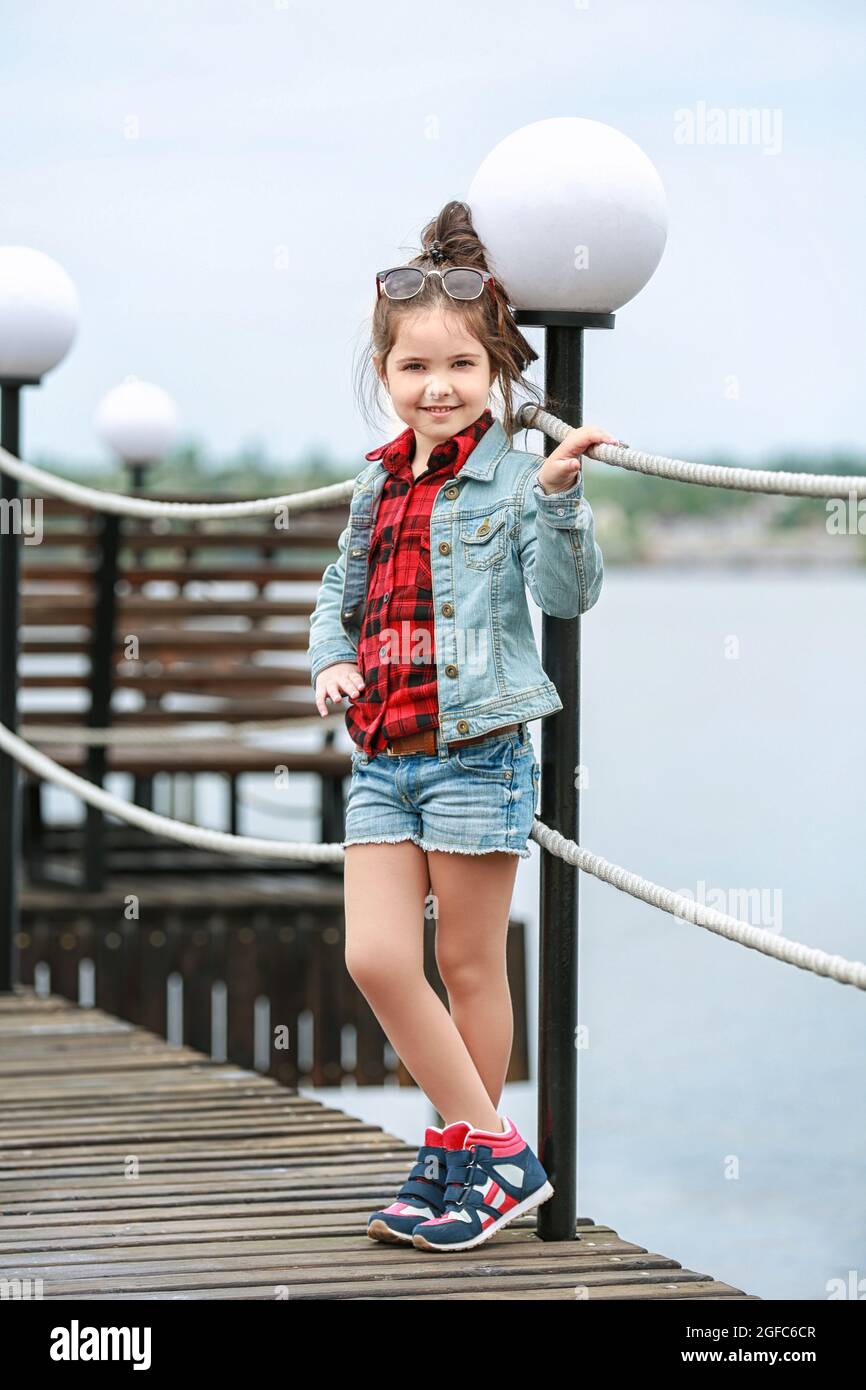 Niña pequeña con ropa al aire libre. Concepto de moda de stock Alamy