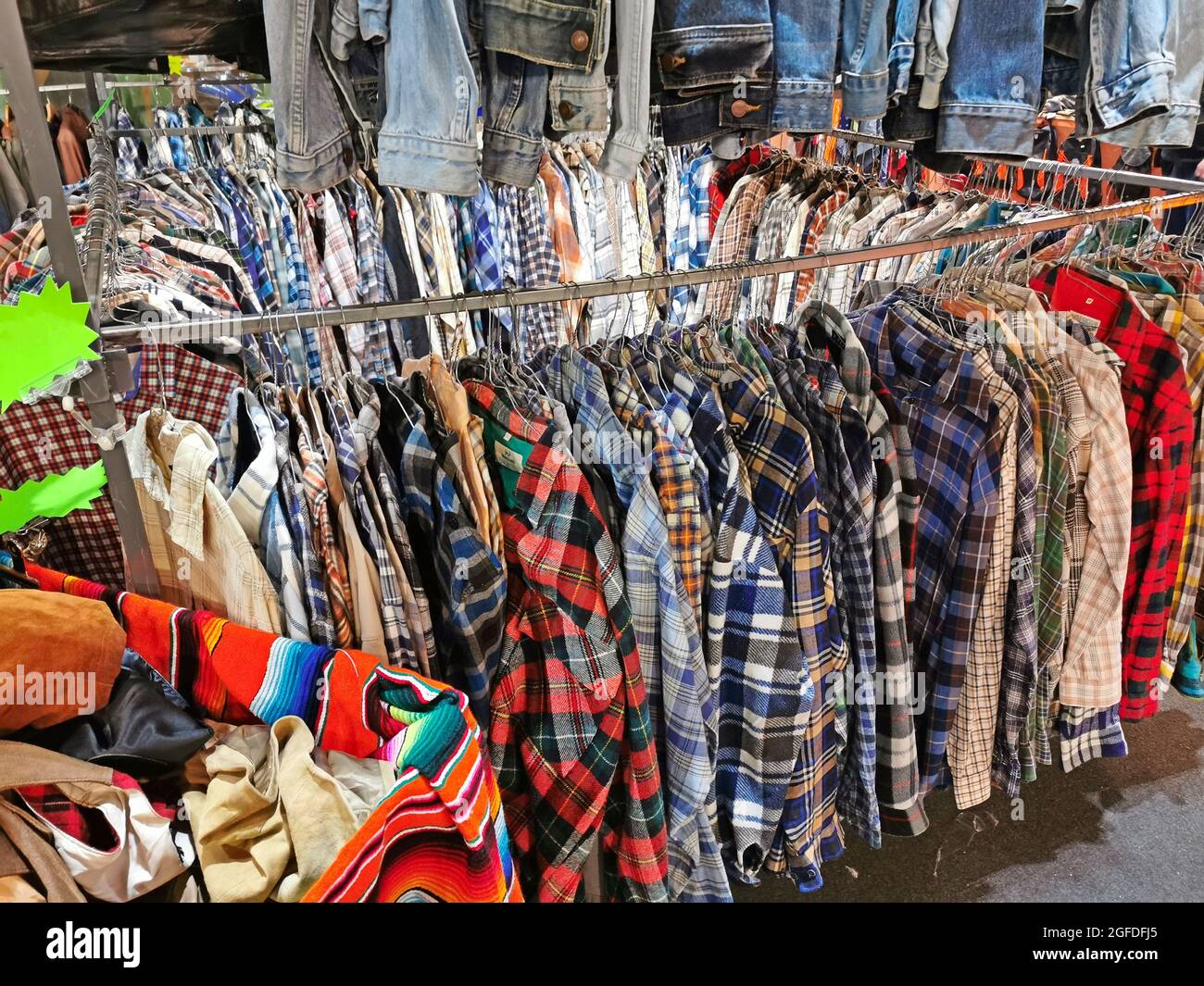 vestidos y camisas la venta en la tienda de ropa usada de stock - Alamy