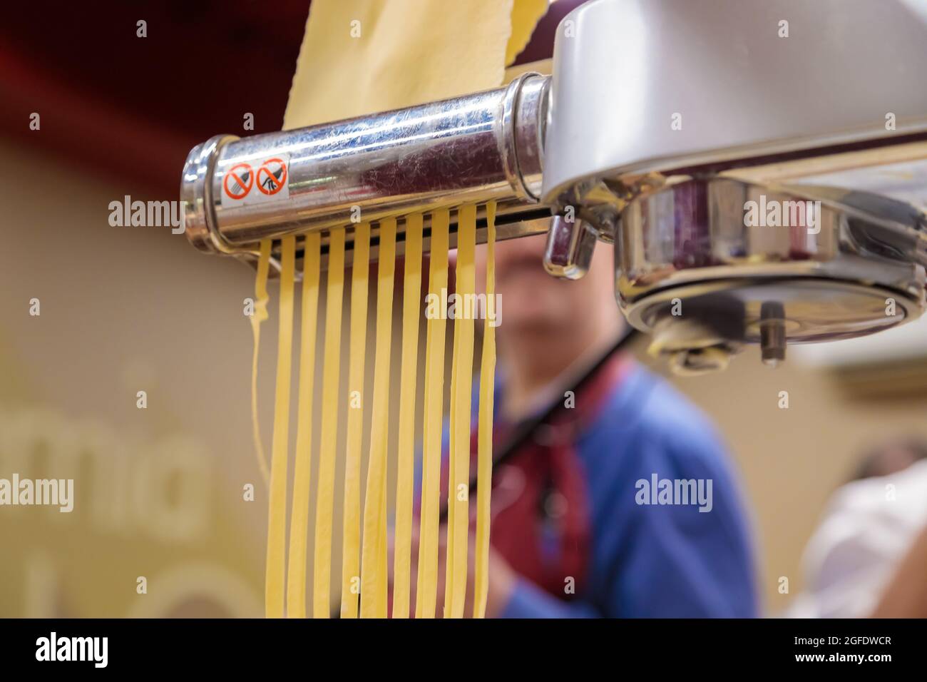 Chef rodando la masa con una máquina de pasta. máquina para hacer pasta.