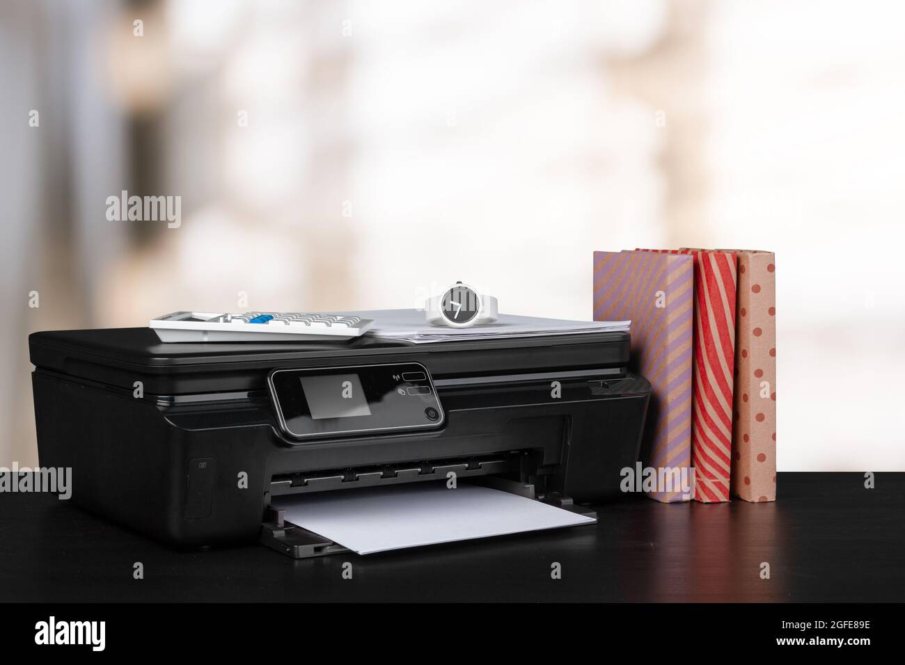 Impresora doméstica compacta en el escritorio con libros sobre fondo borroso  Fotografía de stock - Alamy