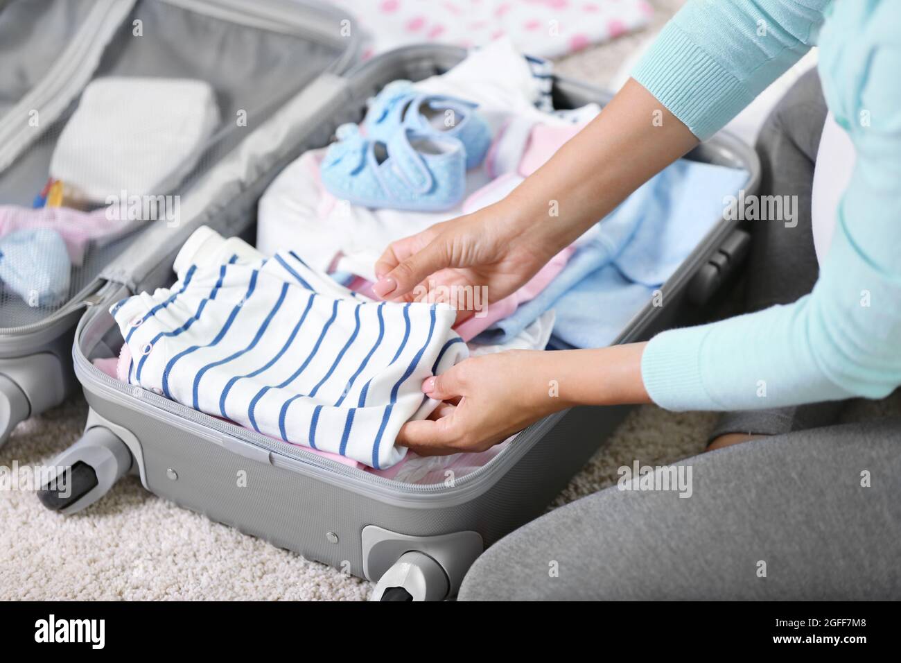 Mujer embarazada empacando una maleta para el hospital de maternidad en  casa