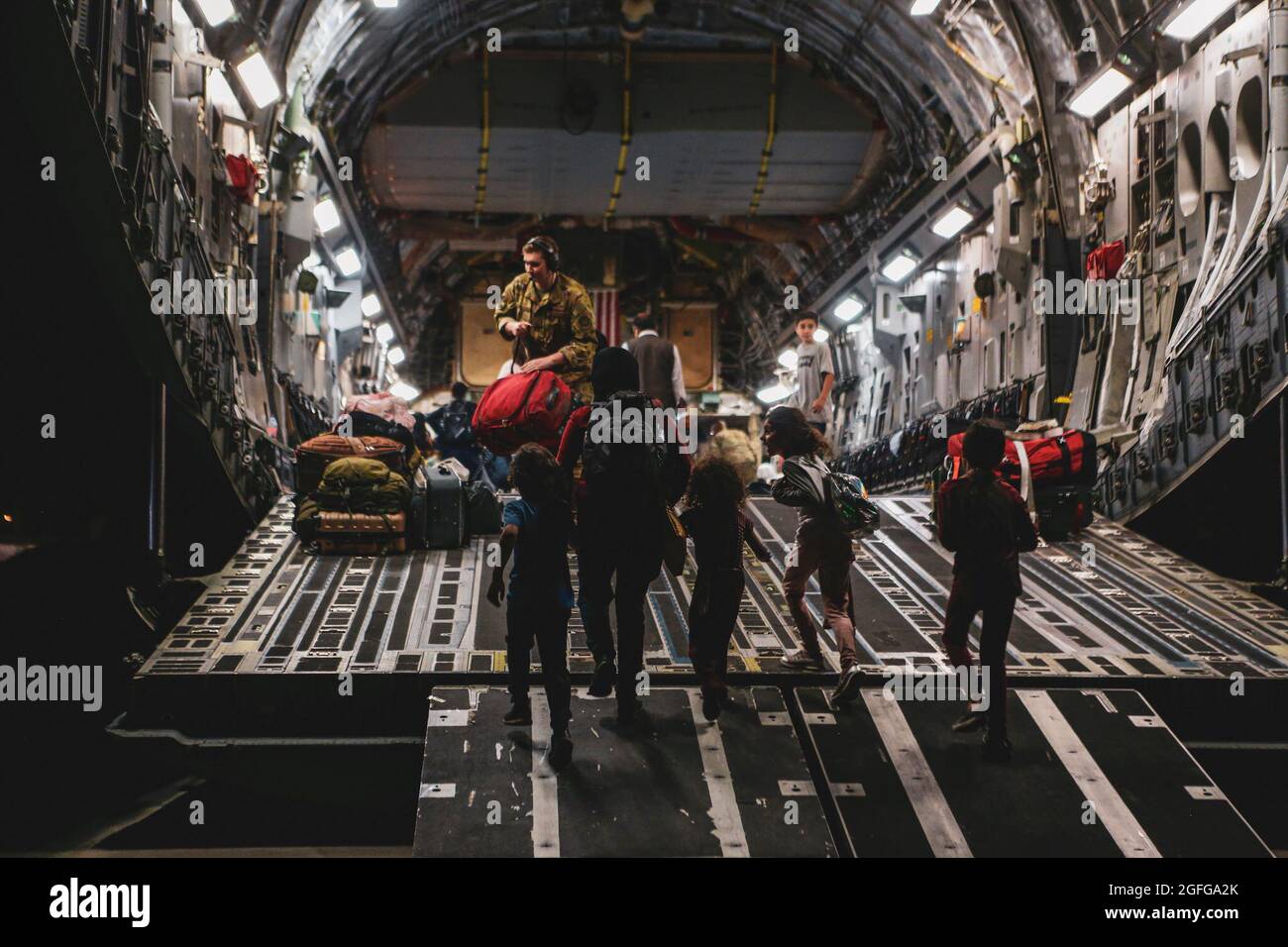 Los evacuados embarzan en un Boeing C-17 Globemaster III durante una evacuación en el Aeropuerto Internacional Hamid Karzai, Kabul, Afganistán, agosto de 23. Los miembros del servicio de los Estados Unidos están ayudando al Departamento de Estado con una Operación de Evacuación de No-Combatientes (NEO) en Afganistán. (EE.UU Marine Corps foto por Sgt. Isaías Campbell) Foto de stock