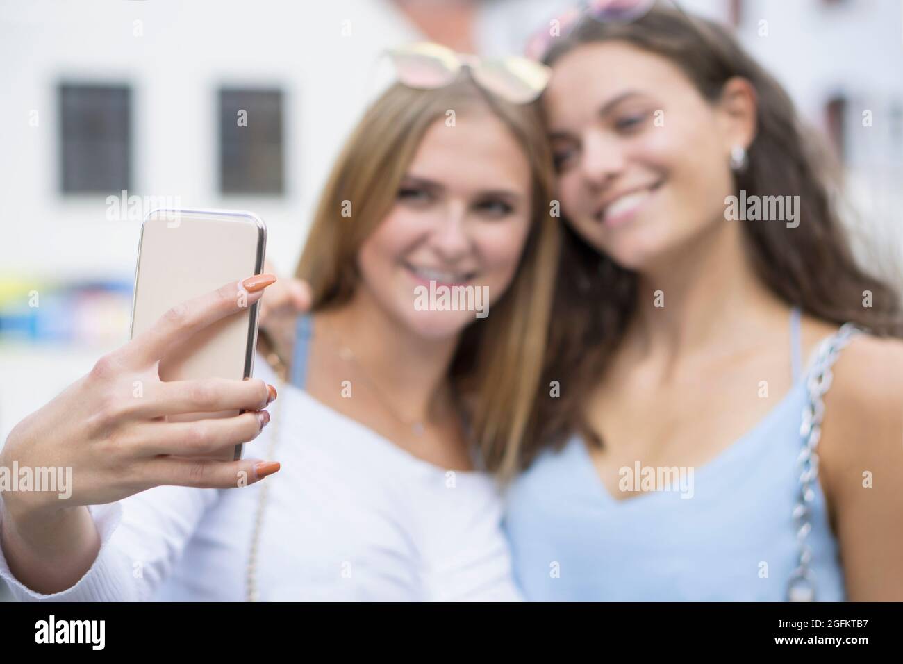 dos mujeres jóvenes haciendo sonreír cabeza a cabeza un selvy Foto de stock