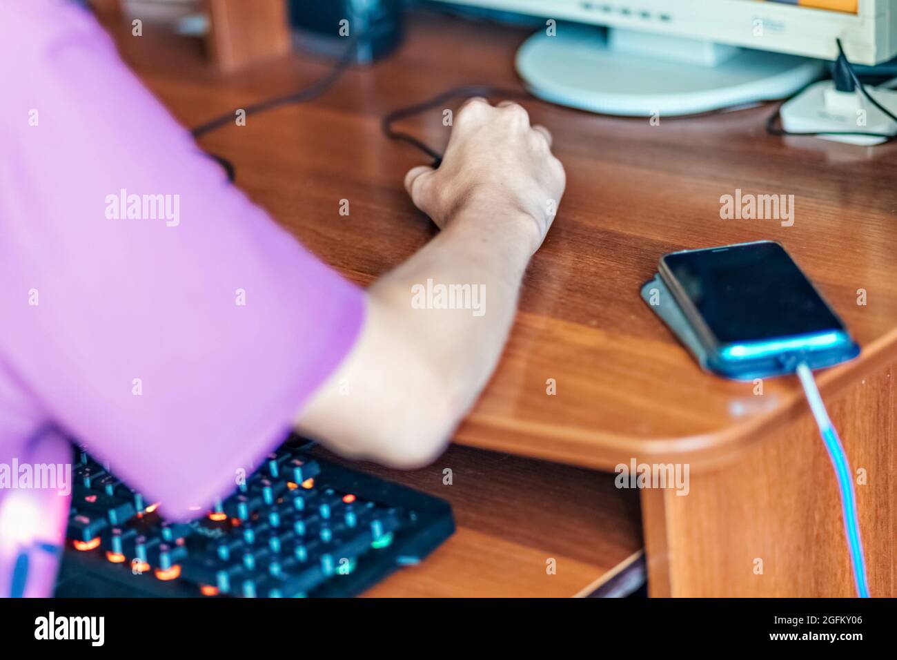 Un adolescente, un joven jugando a videojuegos en una computadora, usando tecnología, usando auriculares, usando un hombre joven, un adolescente usando tec Foto de stock