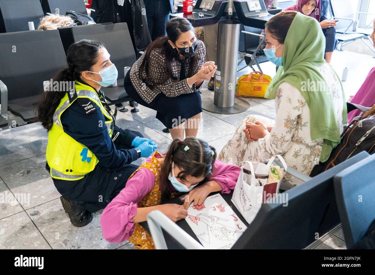 Priti Patel, Secretario del Interior de Gran Bretaña, habla con Malalai Hussiny, un refugiado de Afganistán que llegó en un vuelo de evacuación, al aeropuerto de Heathrow, en Londres, Gran Bretaña, el 26 de agosto de 2021. Dominic Lipinski/Pool vía REUTERS Foto de stock