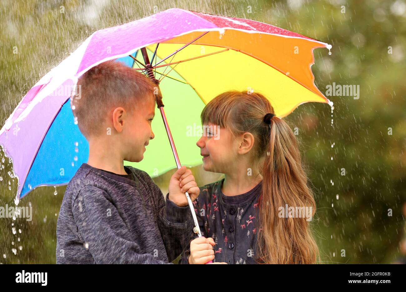 Retrato de niños lindos con paraguas bajo la lluvia Fotografía de stock -  Alamy