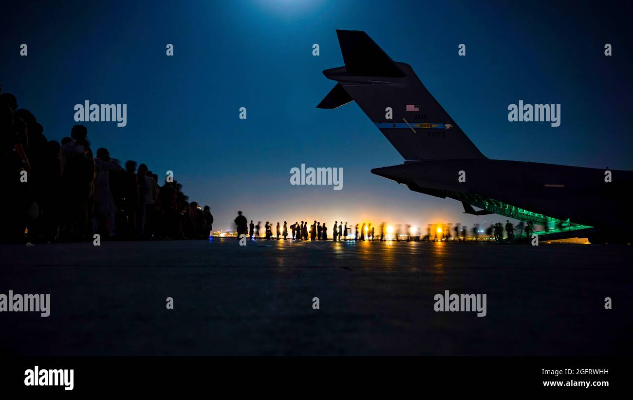 Una tripulación aérea de la Fuerza Aérea de los Estados Unidos, asignada al Escuadrón Expedicionario de Elevación Aérea de 816th, asiste a evacuados calificados que se embarcaran en 17 un avión Globemaster III de la Fuerza Aérea de los Estados Unidos en apoyo de la evacuación de Afganistán en el Aeropuerto Internacional Hamid Karzai, Afganistán, 21 de agosto de 2021. El Departamento de Defensa está comprometido a apoyar al Departamento de Estado de los Estados Unidos en la salida del personal civil estadounidense y aliado de Afganistán, y a evacuar a los aliados afganos de manera segura. (EE.UU Foto de la Fuerza Aérea de Senior Airman Taylor Crul a través de American PhotoArchive/Alamy) Foto de stock