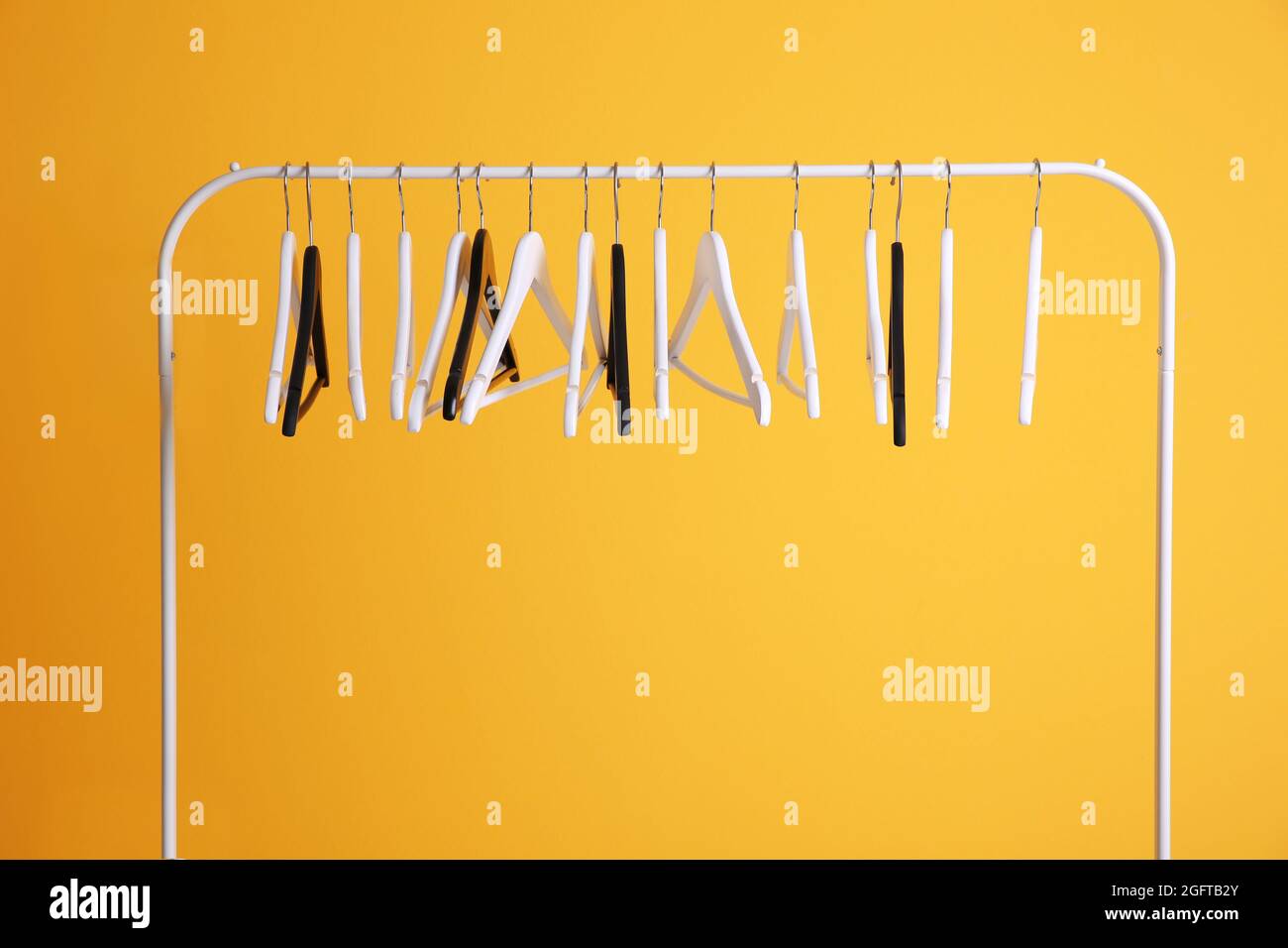 Colgadores modernos sobre fondo amarillo de pared Fotografía de stock -  Alamy
