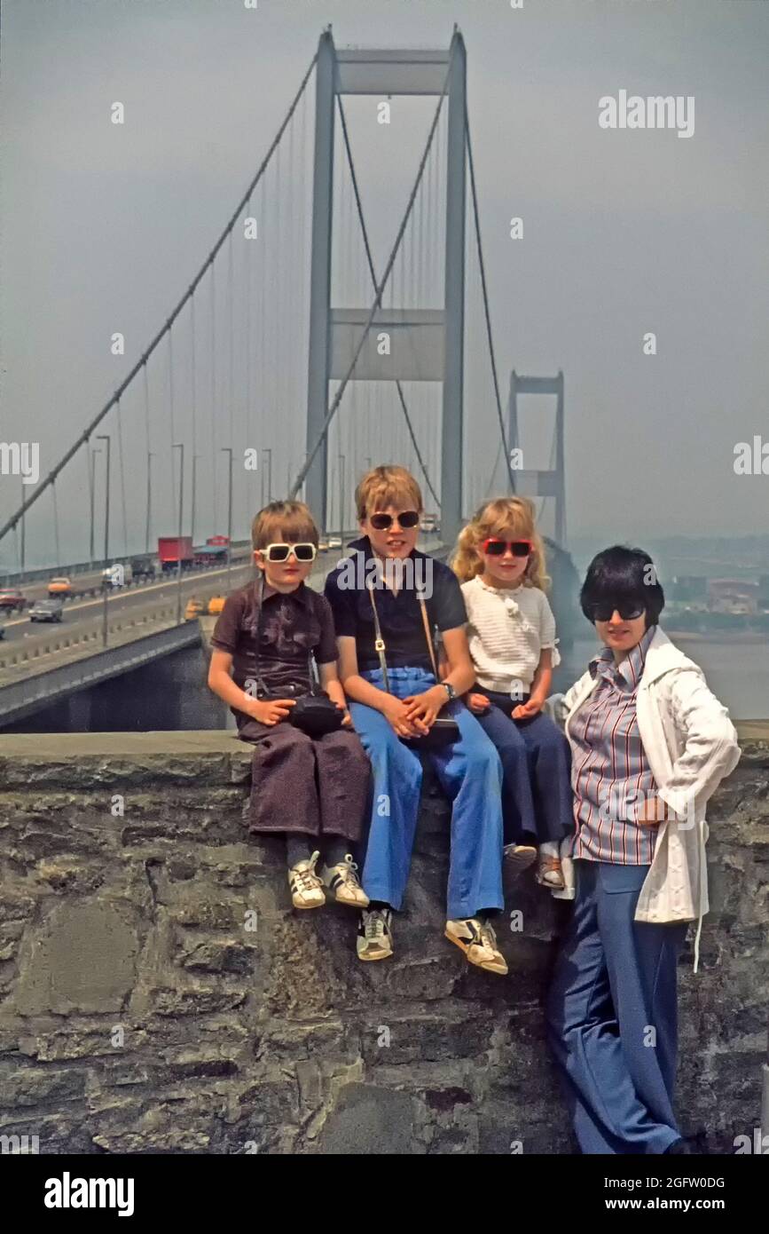 Archivo 1994 vista de los jóvenes 1990s familia de dos niños y una niña con  mamá posando delante de la M4 puente colgante de la autopista cruzando el  río Severn tomando un