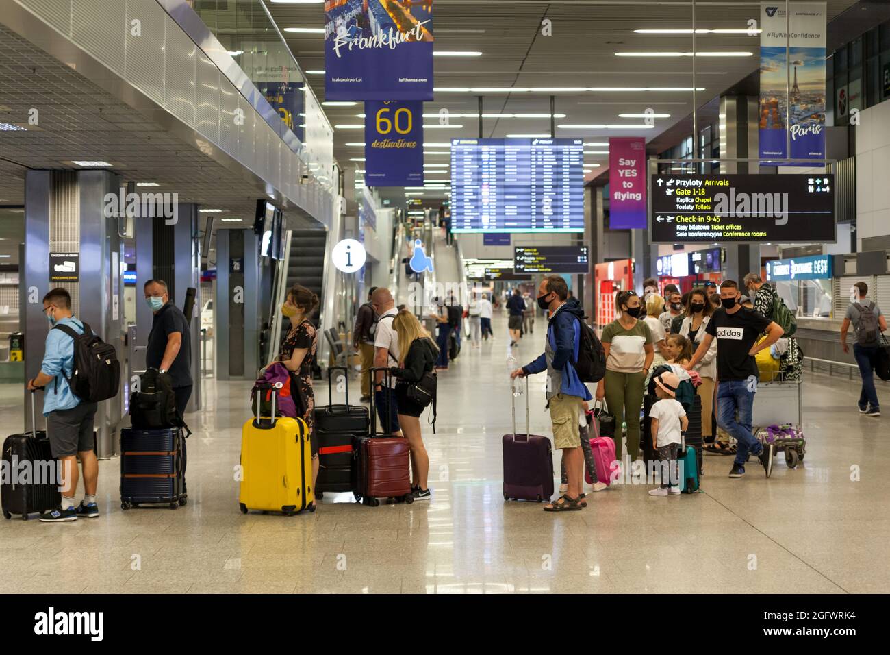 Turistas esperando a dejar su equipaje en la sala de correo de la terminal.  El Aeropuerto Internacional Juan Pablo II de Cracovia es un aeropuerto  internacional LO Fotografía de stock - Alamy