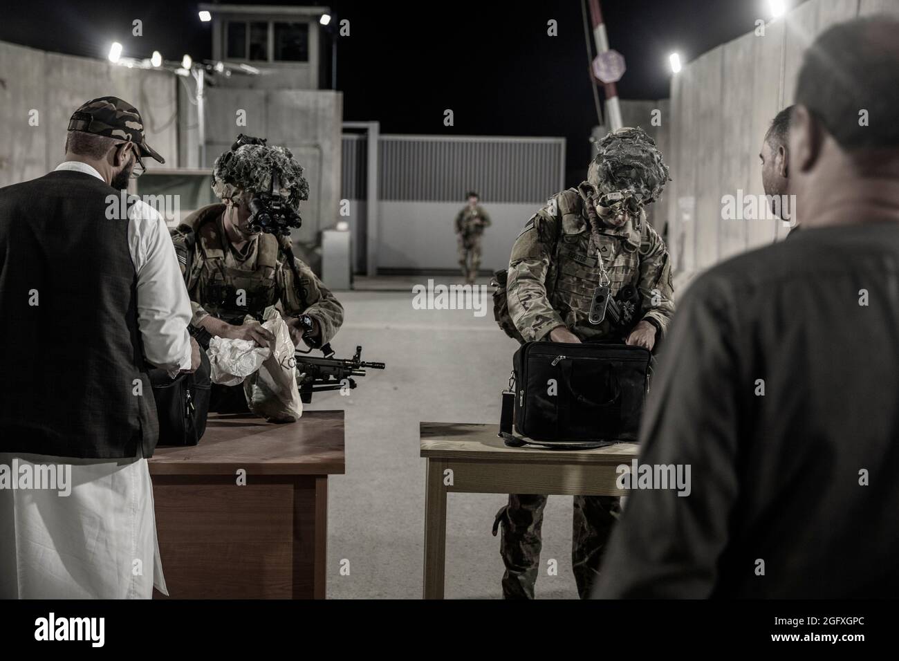 Los Soliders estadounidenses con la División Aerotransportada de 82nd verifican a los evacuados durante una evacuación en el Aeropuerto Internacional Hamid Karzai, Kabul, Afganistán, agosto de 25. Los miembros del servicio de los Estados Unidos están ayudando al Departamento de Estado con una operación de evacuación no combatiente (NEO) en Afganistán. (EE.UU Foto del cuerpo marino por el personal Sgt. Victor Mancilla) Foto de stock