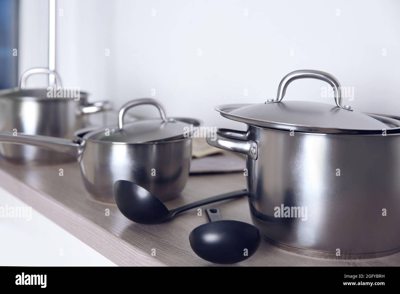Menaje concepto. Cacerolas de acero inoxidable en la mesa de la cocina  Fotografía de stock - Alamy