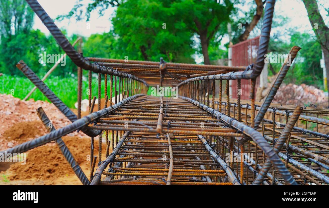 El edificio bajo construcción espera el vertido de losas de hormigón. El cableado de metal oxidado se coloca en el suelo de la casa en construcción. Foto de stock