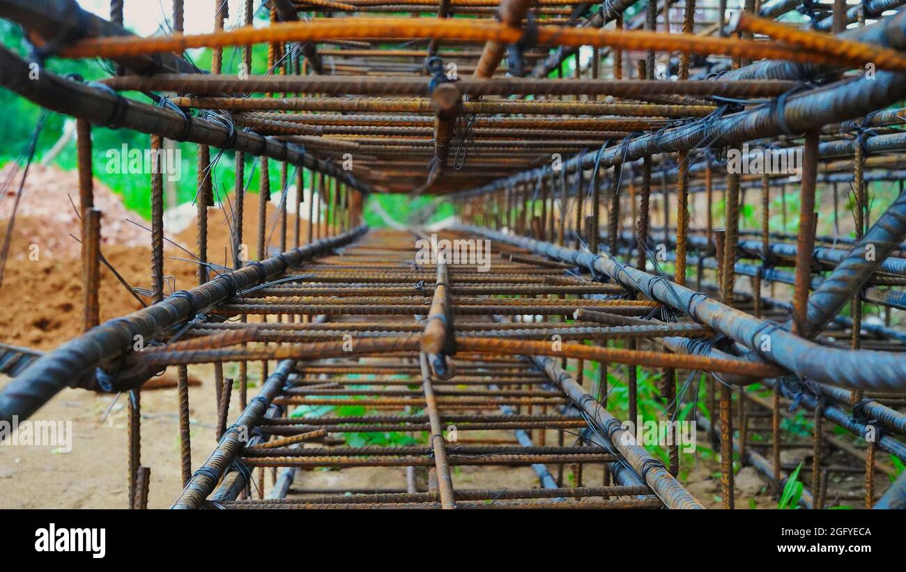 El edificio bajo construcción espera el vertido de losas de hormigón. El cableado de metal oxidado se coloca en el suelo de la casa en construcción. Foto de stock