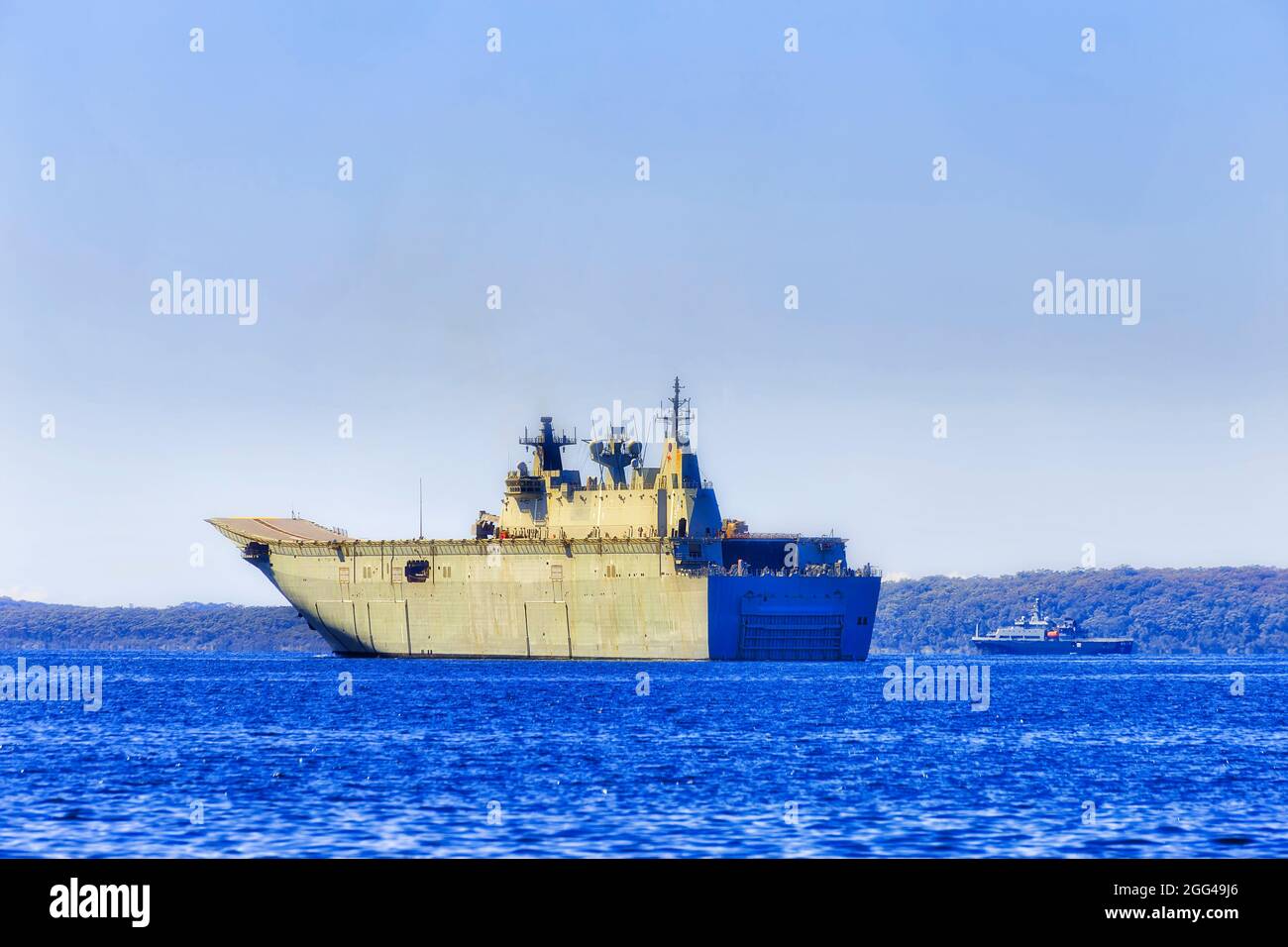 Su Majestad el buque australiano en ejercicio naval en la bahía de Jervis de la costa del Pacífico en Australia - buque insignia de la compañía de helicópteros LHD gigante. Foto de stock