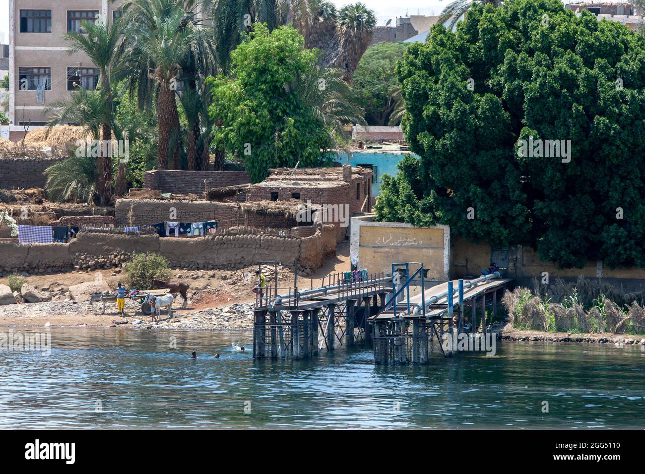 Una escena de la orilla del río Nilo mostrando un embarcadero de bombeo de agua y una casa de ladrillos de barro en Luxor en Egipto. Foto de stock