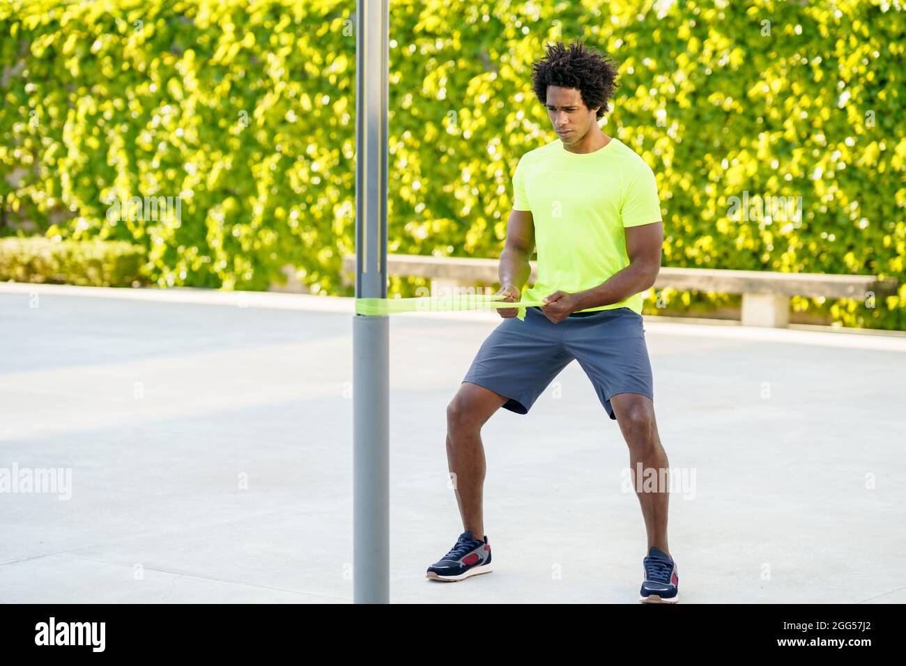 Hombre negro haciendo ejercicio con banda elástica al aire libre Foto de stock