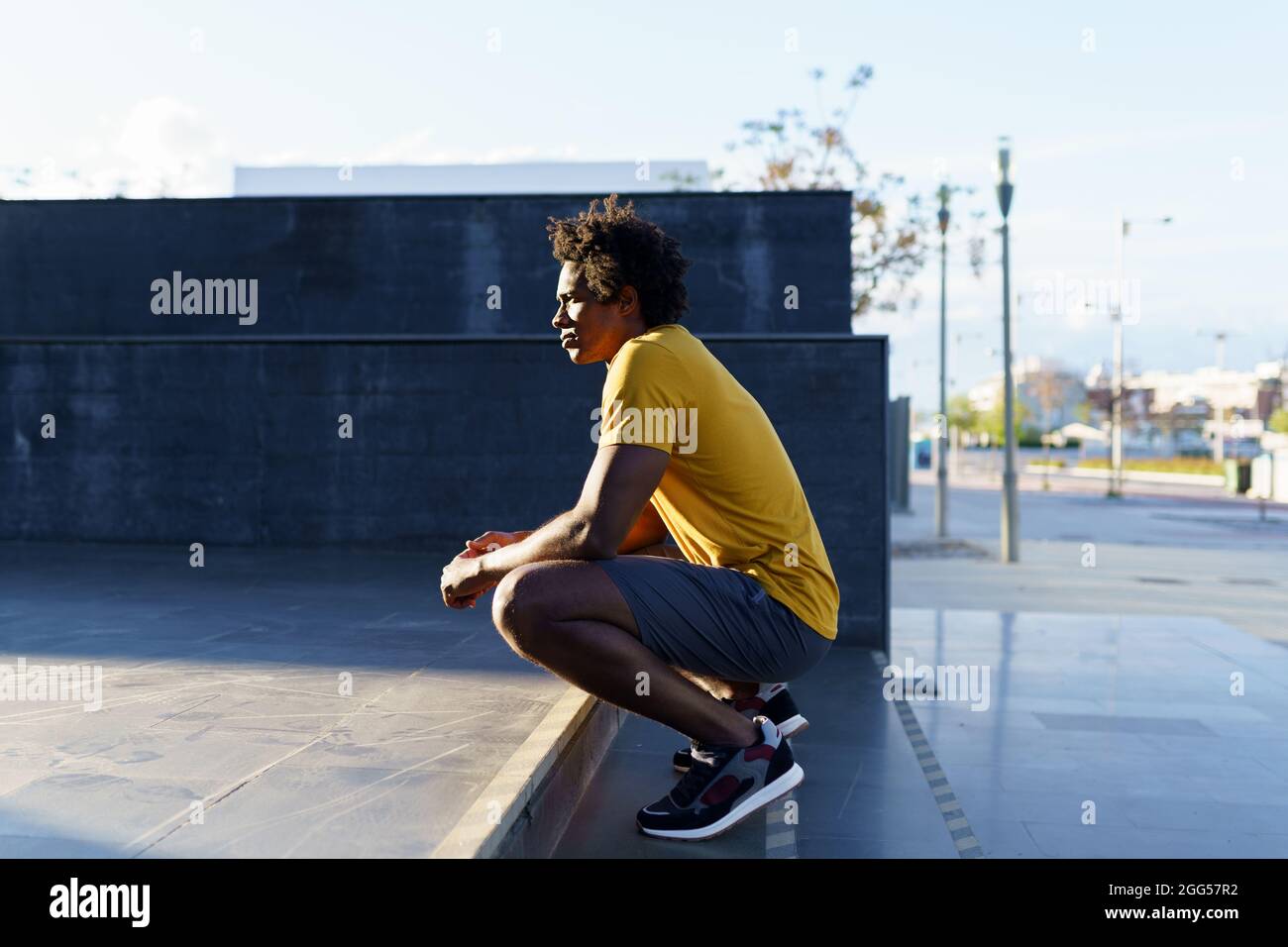 Hombre negro con pelo afro tomando un descanso después del entrenamiento. Foto de stock