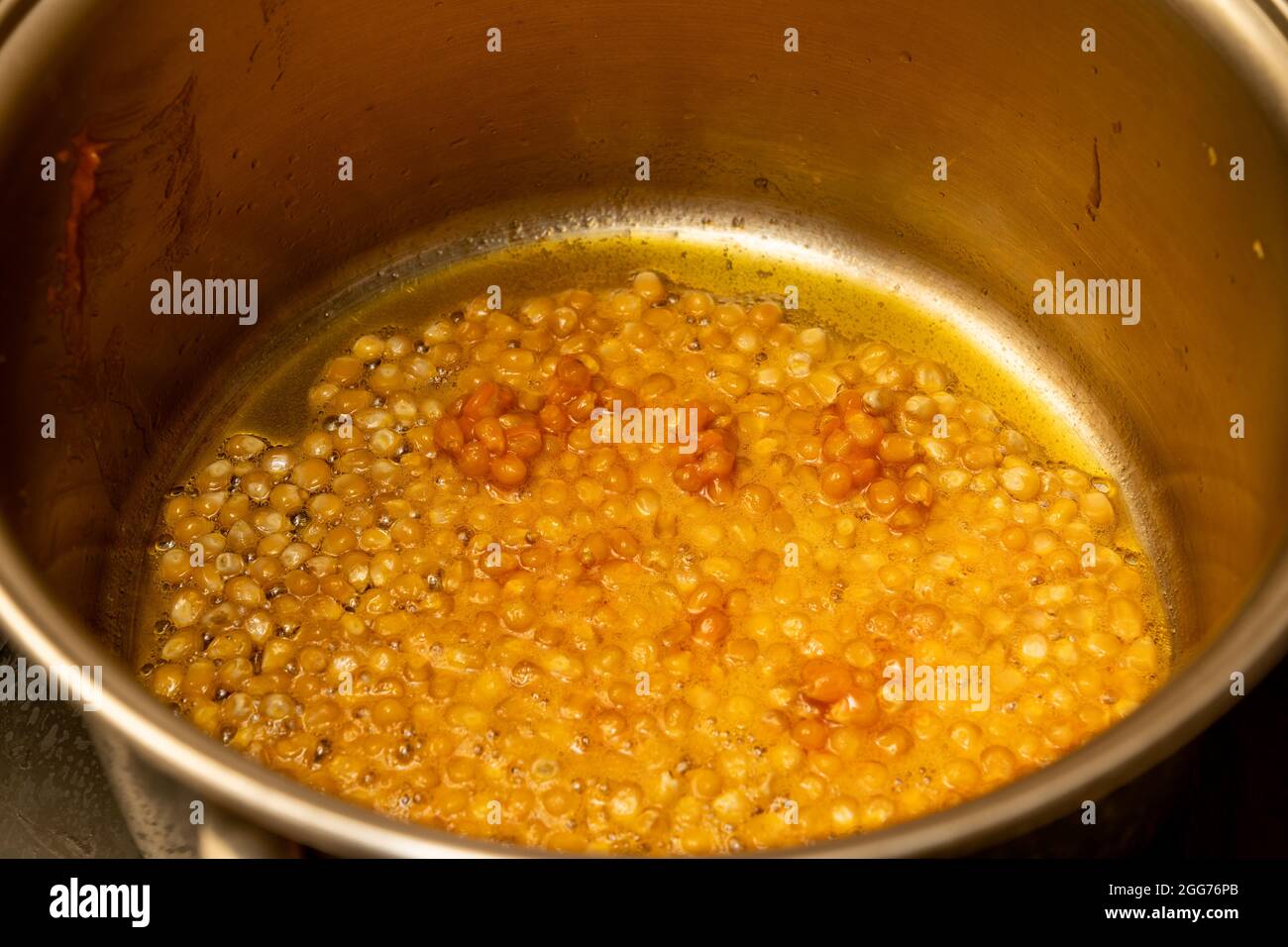 Excéntrico Inseguro equilibrar La olla de la cocina está llena de granos de maíz y una masa de especias de  pasteles para hacer palomitas de maíz Fotografía de stock - Alamy