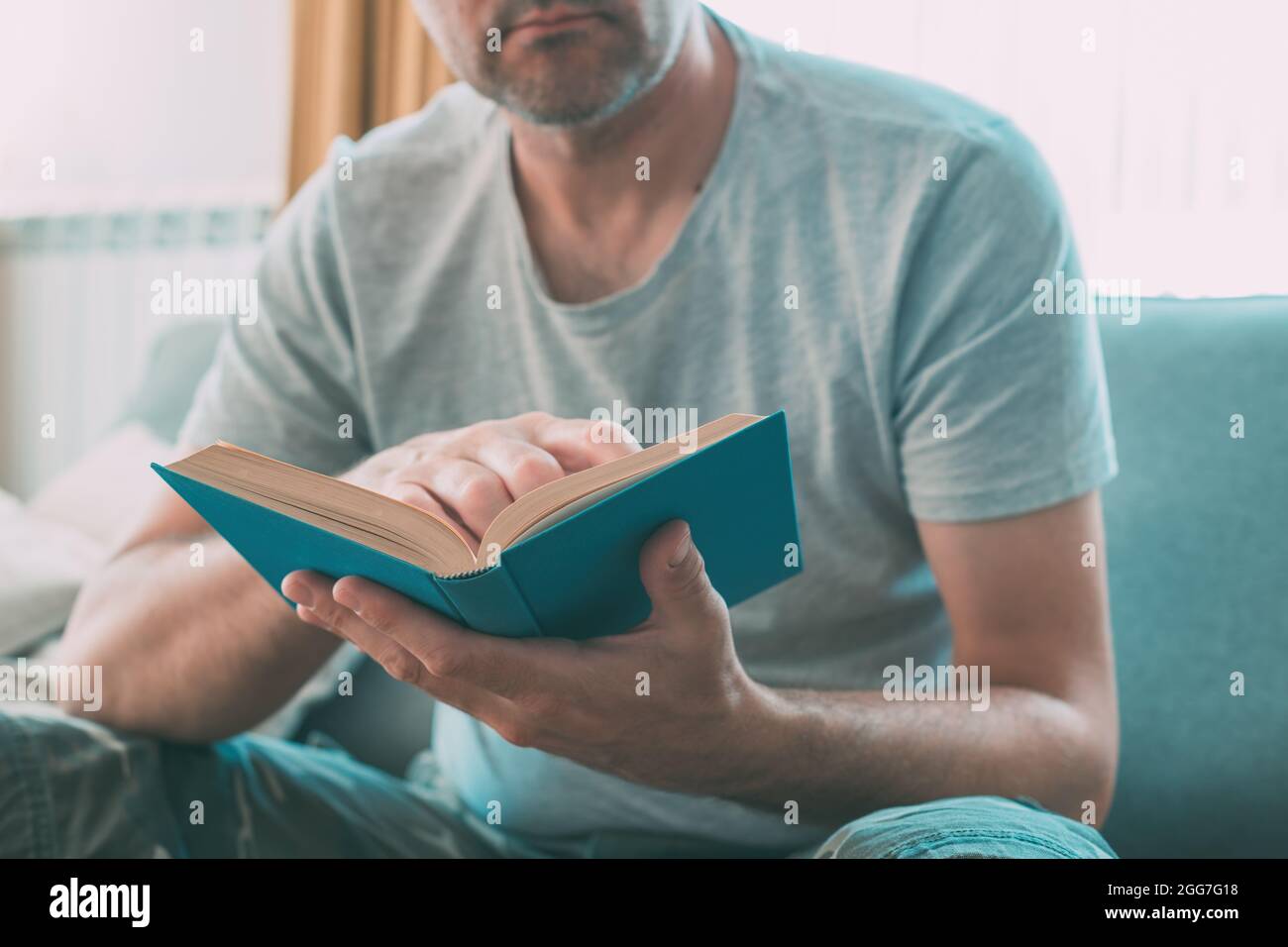 Hombre leyendo libro en casa, disfrutando de una buena lectura sola,  enfoque selectivo Fotografía de stock - Alamy