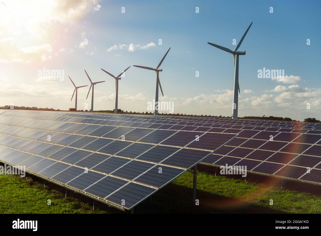 Generadores de energía de turbinas eólicas y paneles solares en parque eólico Foto de stock