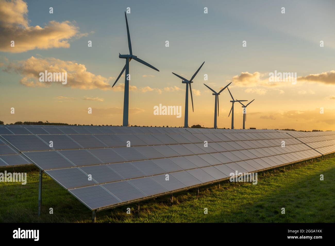 Generadores de energía de turbinas eólicas y paneles solares en parque eólico Foto de stock