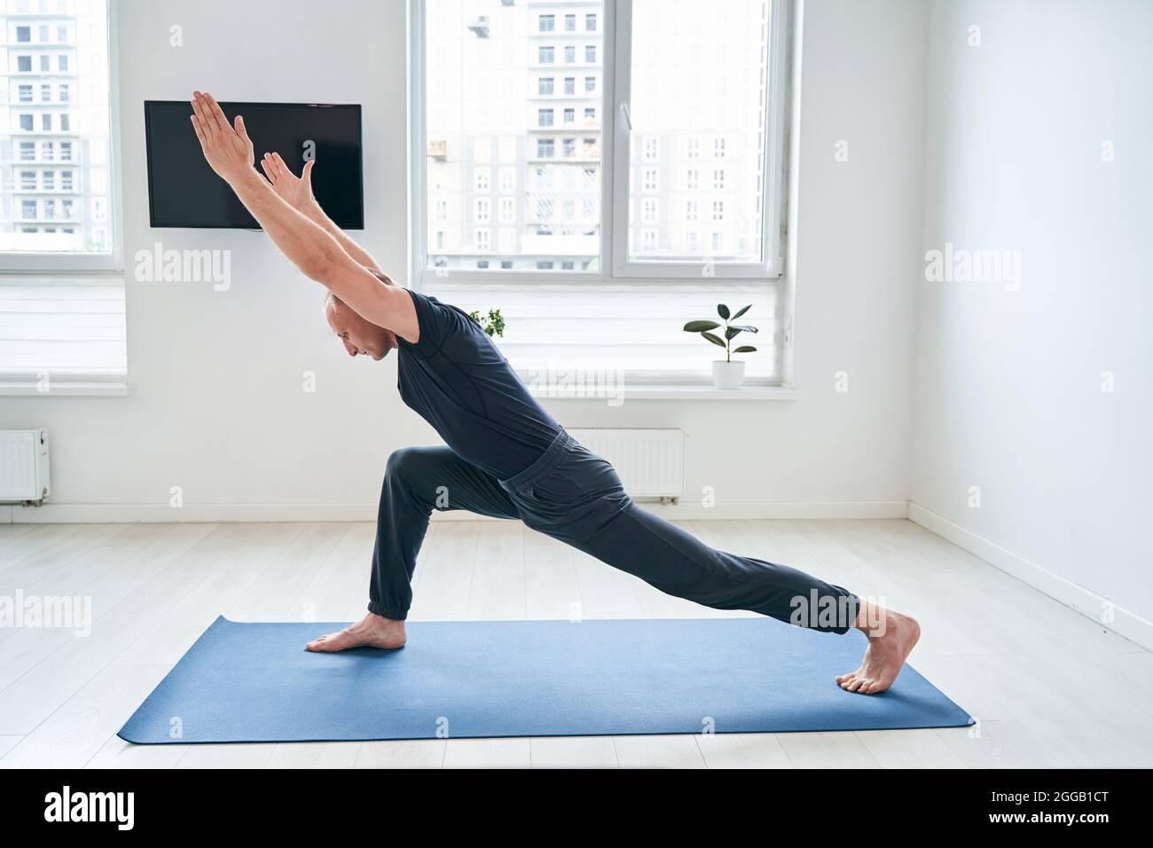 Hombre musculoso pulcro con ropa activa que practica la postura de yoga en  el estudio Fotografía de stock - Alamy