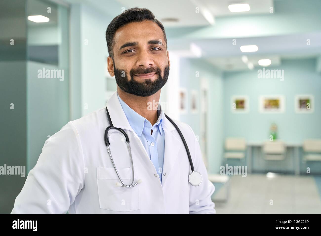 Retrato de un médico indio de pie en un hospital clínico mirando la cámara. Foto de stock