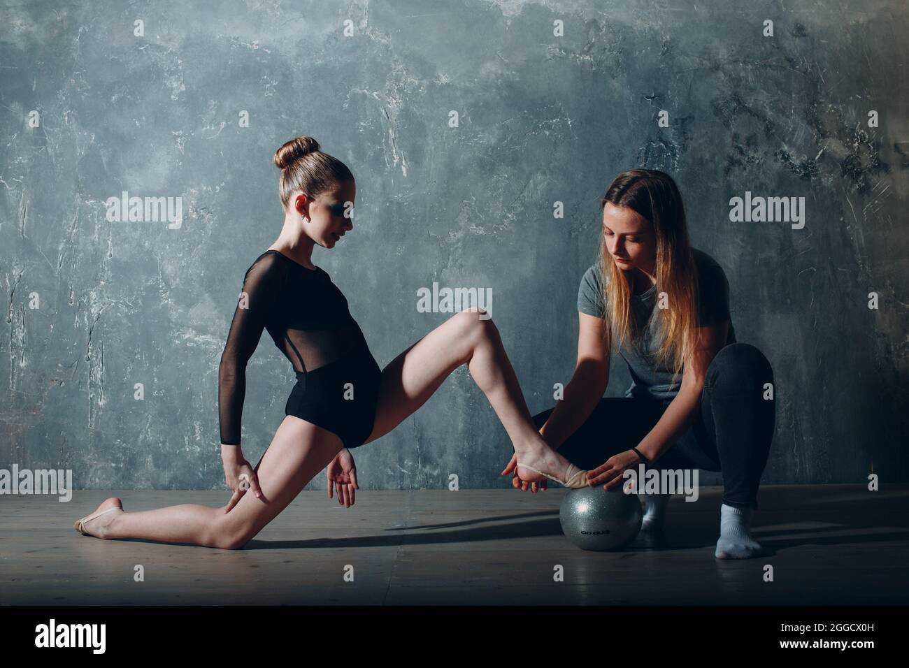 Joven chica profesional gimnasta con entrenador mujer danza gimnasia rítmica  en el estudio Fotografía de stock - Alamy