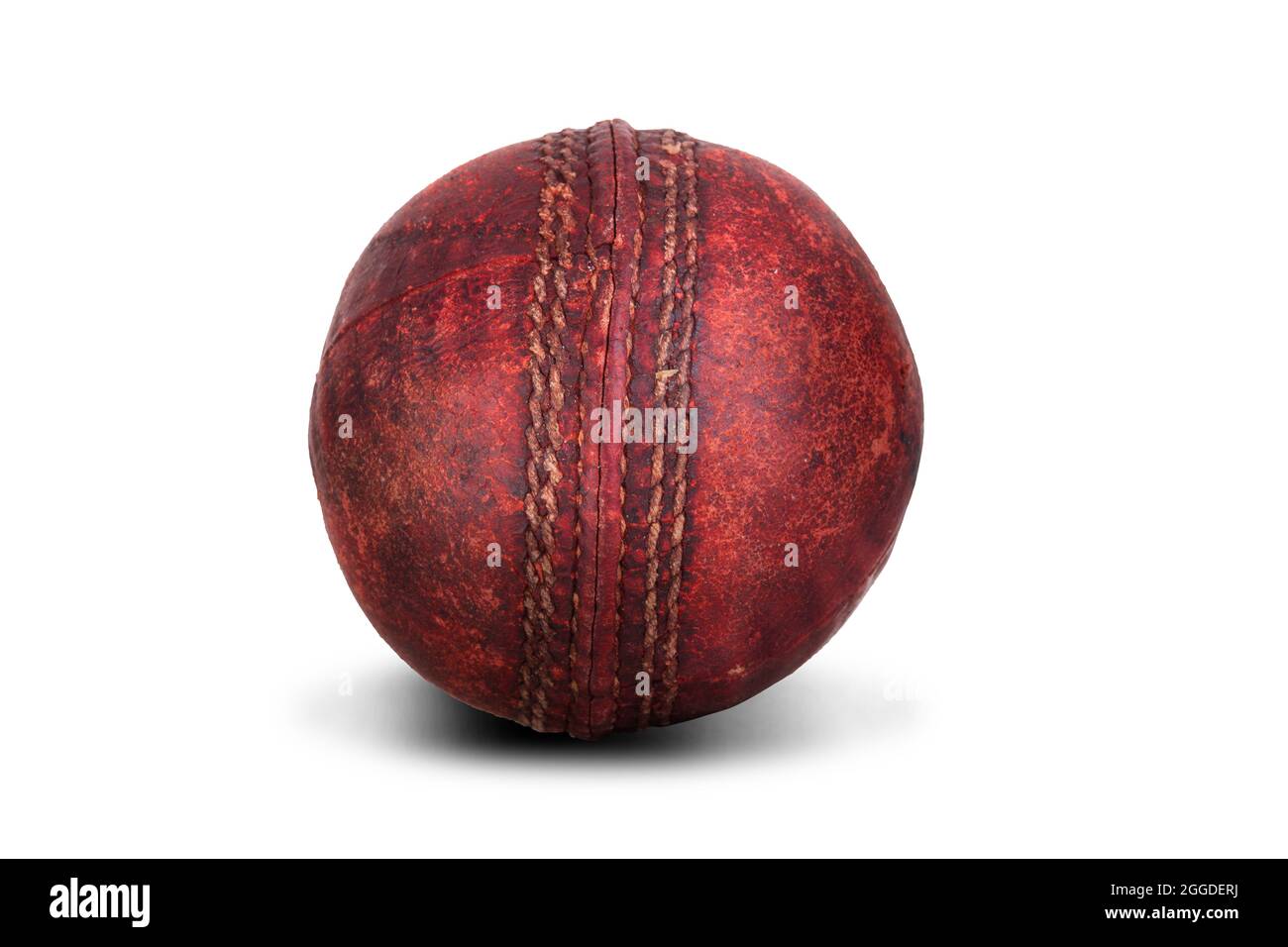 Piel de bola de cricket roja vieja con pespuntes aislados sobre un fondo blanco. Equipo deportivo desgastado Foto de stock