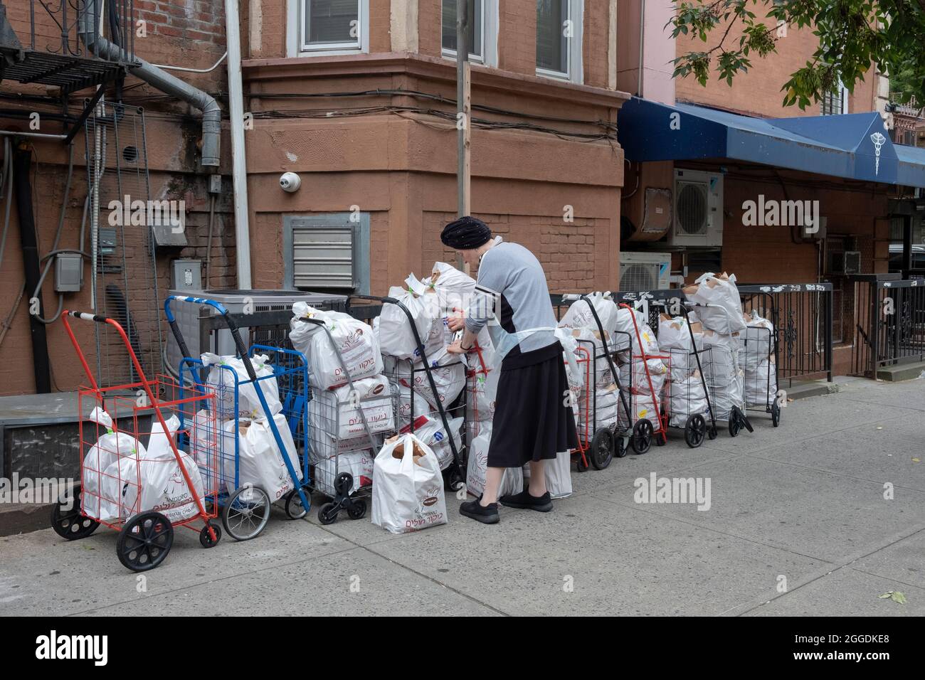 Un voluntario del grupo judío ortodoxo Satmar prepara paquetes de alimentos para ser dados a los necesitados y a aquellos en hospitales que necesitan comida kosher de glatt. Foto de stock