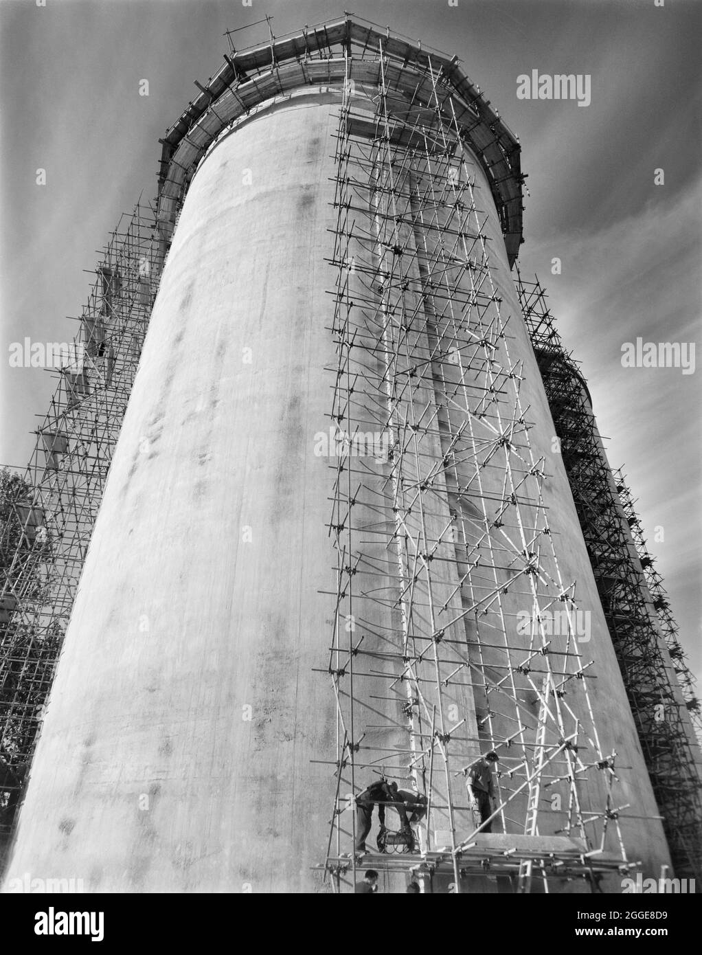 Mirando desde la base de un silo de azúcar recientemente construido en la fábrica de remolacha azucarera Allscott, mostrando una torre de andamiaje erigida para llevar a cabo la tensión posterior de los cables de tensión que corren alrededor del silo. Una fábrica de remolacha azucarera estuvo en Allscott desde 1927 hasta que cerró en 2007. Laing construyó dos silos de azúcar aquí en 1961 para la British Sugar Corporation, que eran los propietarios del sitio. Cada silo fue capaz de almacenar 10.000 toneladas de azúcar granulada y en el momento en que fueron construidas, eran las más altas que Laing había construido hasta ahora usando encofrado deslizante. Los cables de tensión se tensan después de wi Foto de stock