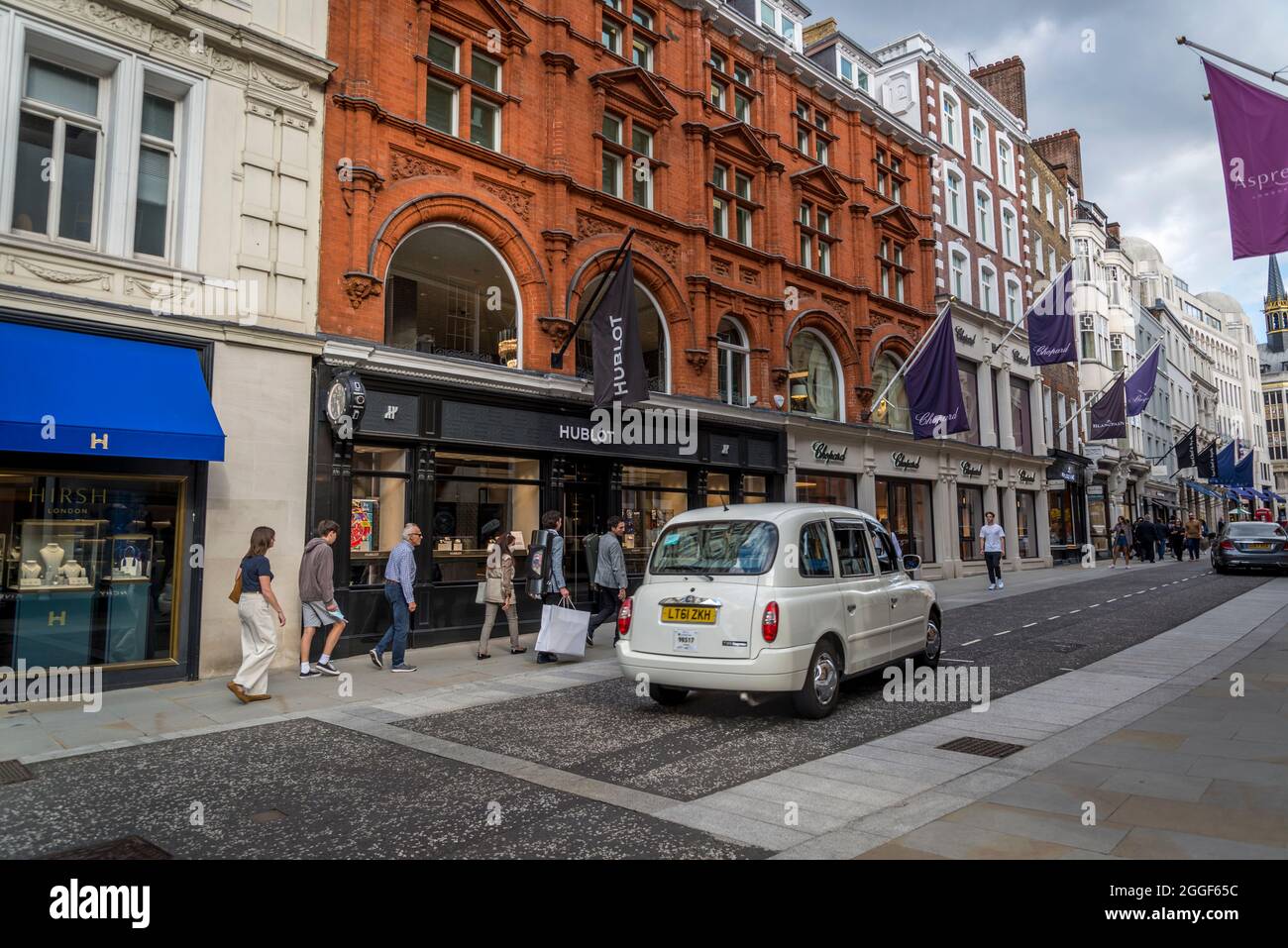 Un taxi blanco de Londres pasa por New Bond Street, Londres, Inglaterra, Reino Unido Foto de stock