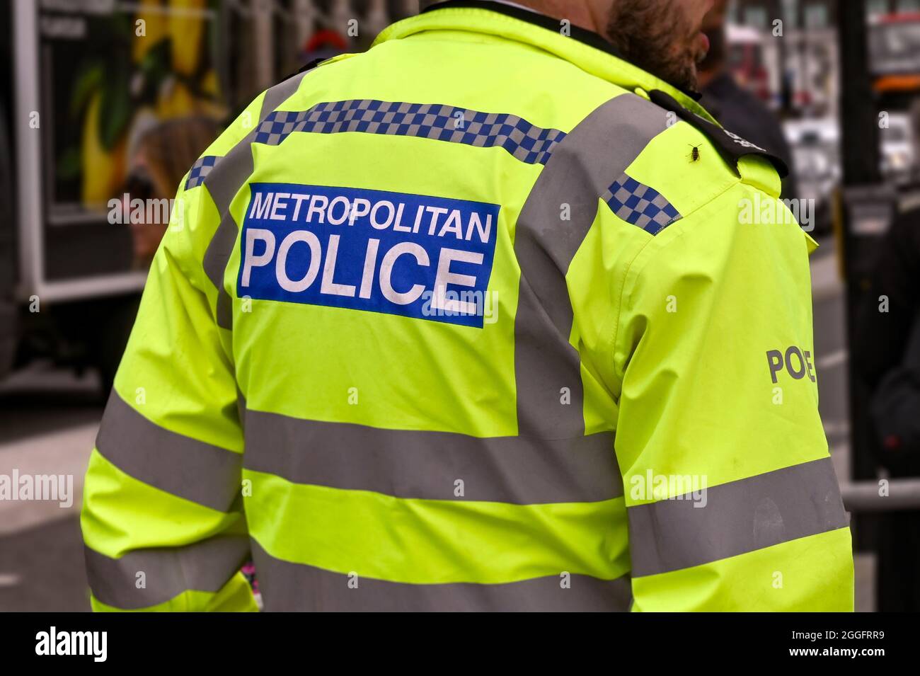Londres, Inglaterra - 2021 de agosto: Vista posterior de un oficial de la Policía Metropolitana que lleva una chaqueta reflectante. Foto de stock