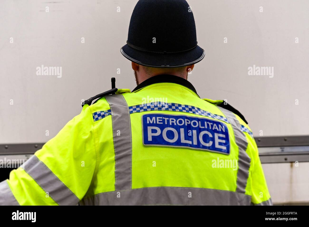 Londres, Inglaterra - 2021 de agosto: Vista posterior de un oficial de la Policía Metropolitana que lleva una chaqueta reflectante. Foto de stock