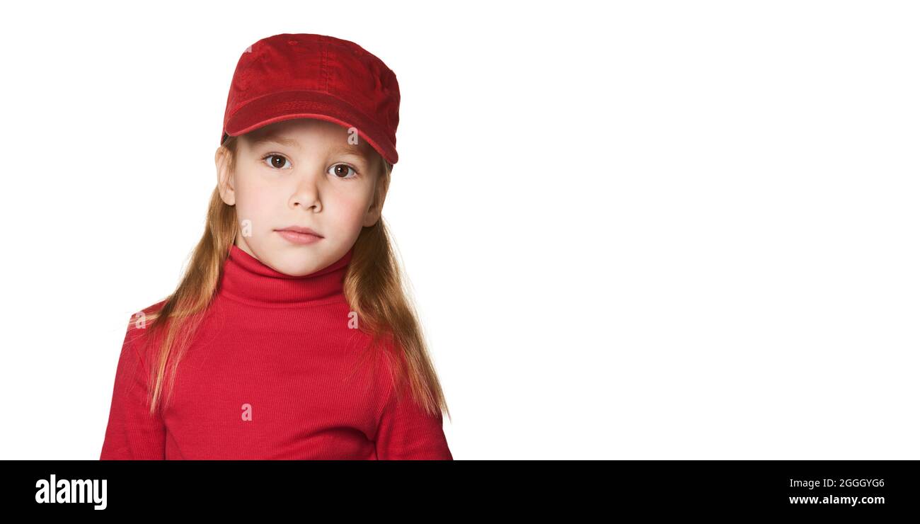 Chica con gorra roja de béisbol. Niño en un cuello de cuello rojo y un casquillo rojo de baselball aislado sobre fondo blanco. Foto de stock