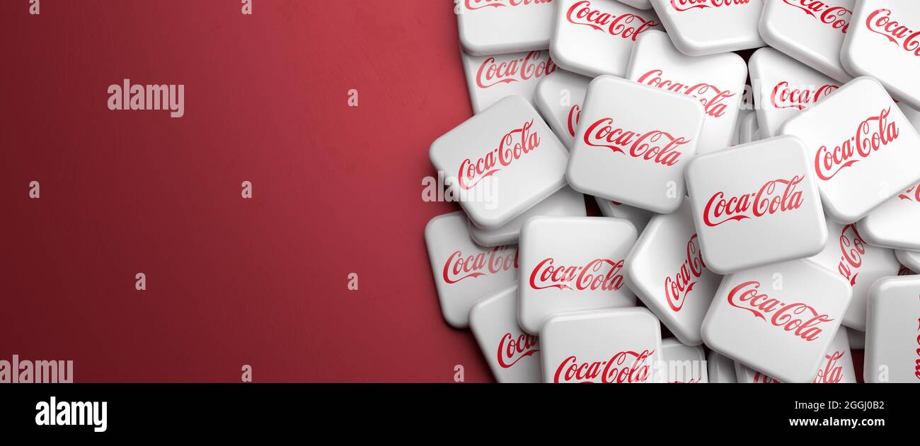 Logotipos de la empresa de bebidas Coca-Cola en un montón sobre una mesa.  Espacio de copia. Formato de banner web Fotografía de stock - Alamy