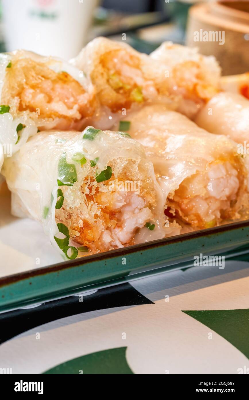 Un plato de delicioso té cantonés por la mañana dim sum crujientes rollos de arroz de camarón Foto de stock