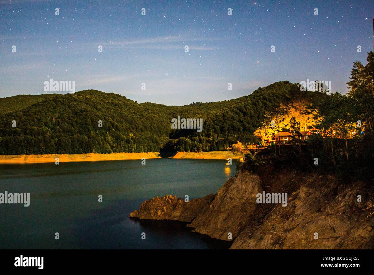 Lago Vidraru en el condado de Arges, Rumania, que refleja el cielo nocturno. Foto de stock
