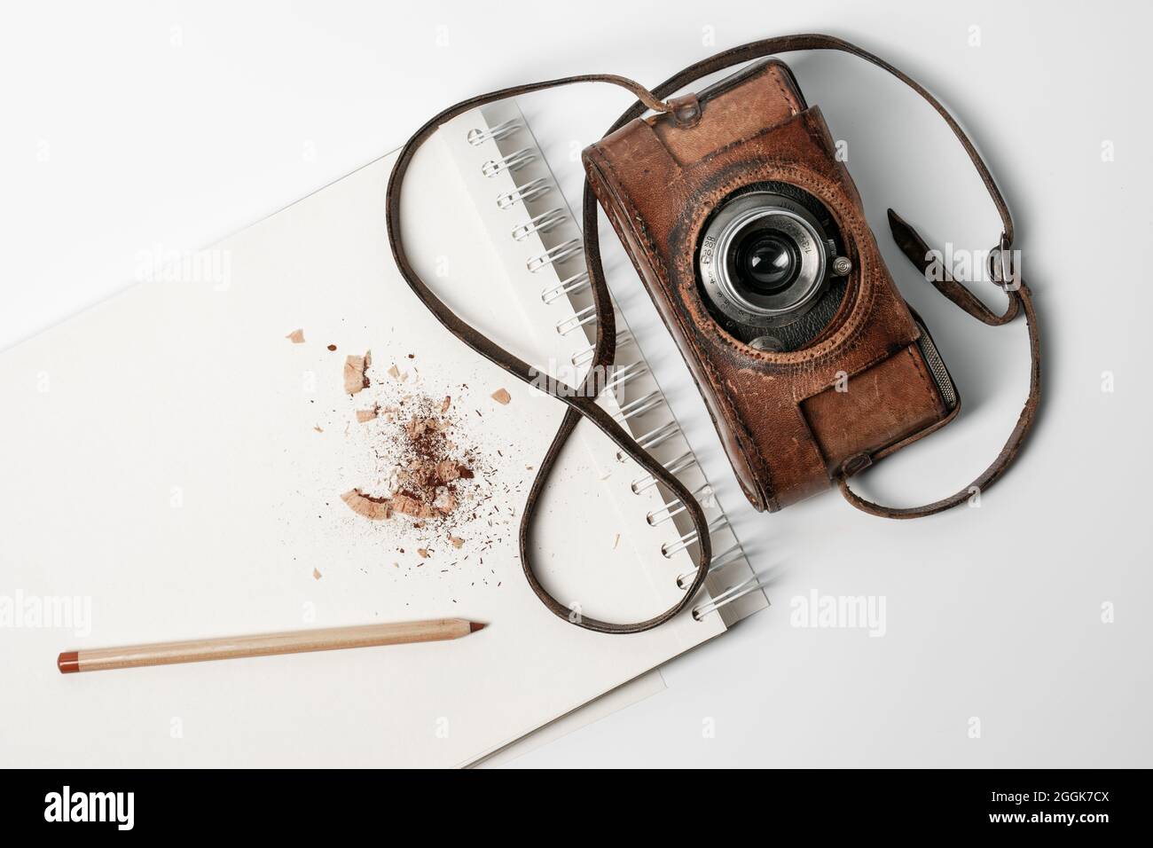 Portátil con lápiz marrón y cámara de película antigua sobre fondo blanco  Fotografía de stock - Alamy
