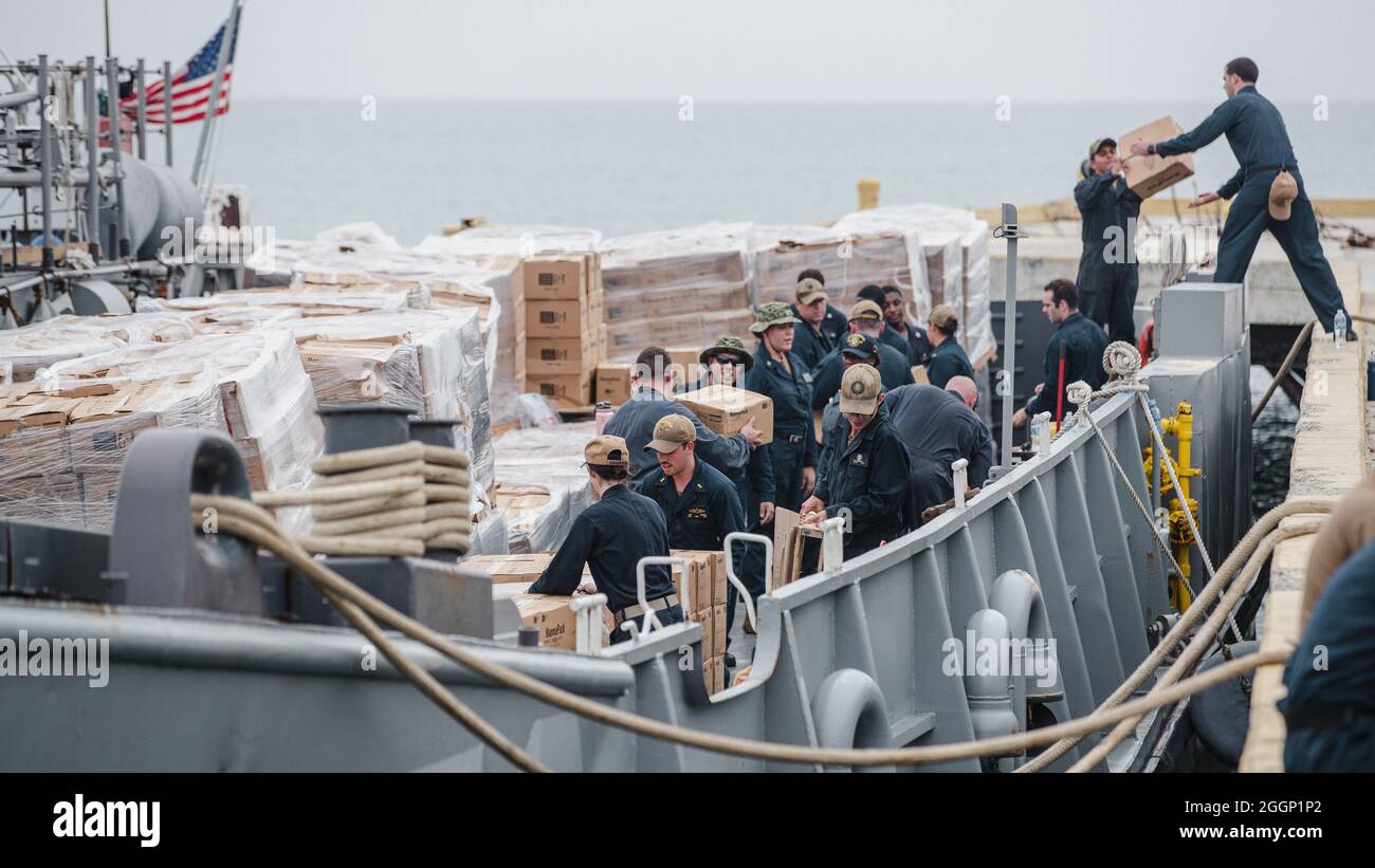 Los marineros estadounidenses con Joint Task Force-Haiti (JTF-Haití) ayudan a descargar cajas para la redistribución en Puerto de Jeremie, Haití, 31 de agosto de 2021. Los infantes de marina y marineros a bordo del USS Arlington (LPD 24) han estado trabajando en apoyo de la JTF-Haití para una misión de asistencia humanitaria y socorro en casos de desastre. (EE.UU Marine Corps foto por Lance Cpl. Jacqueline C. Arre) Foto de stock