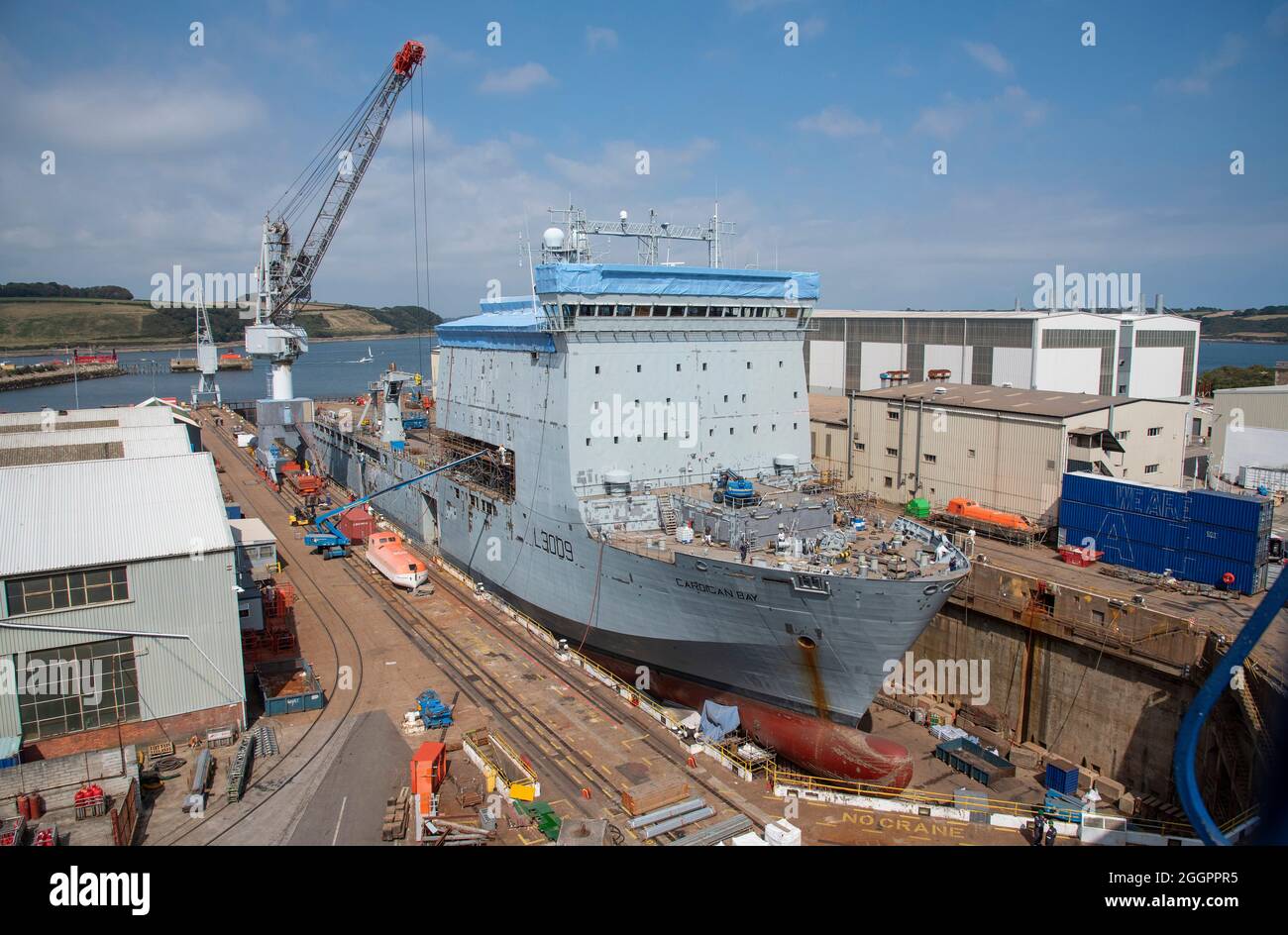 Falmouth, Cornwall, Inglaterra, Reino Unido. 2021. El depósito de RFA Cardigan Bay en muelle seco se está rearmando. Contratistas repintando el buque. Foto de stock