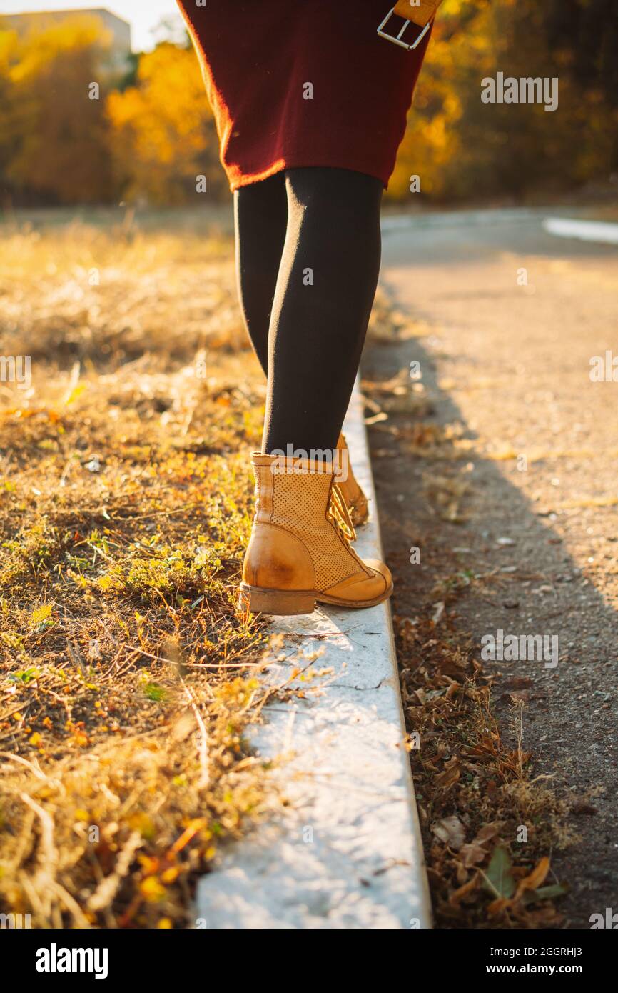 Feliz otoño, hola otoño, temporada de otoño. Piernas femeninas en botas  amarillas caminando a lo largo del bordillo con hojas de otoño. Calzado de  otoño Fotografía de stock - Alamy